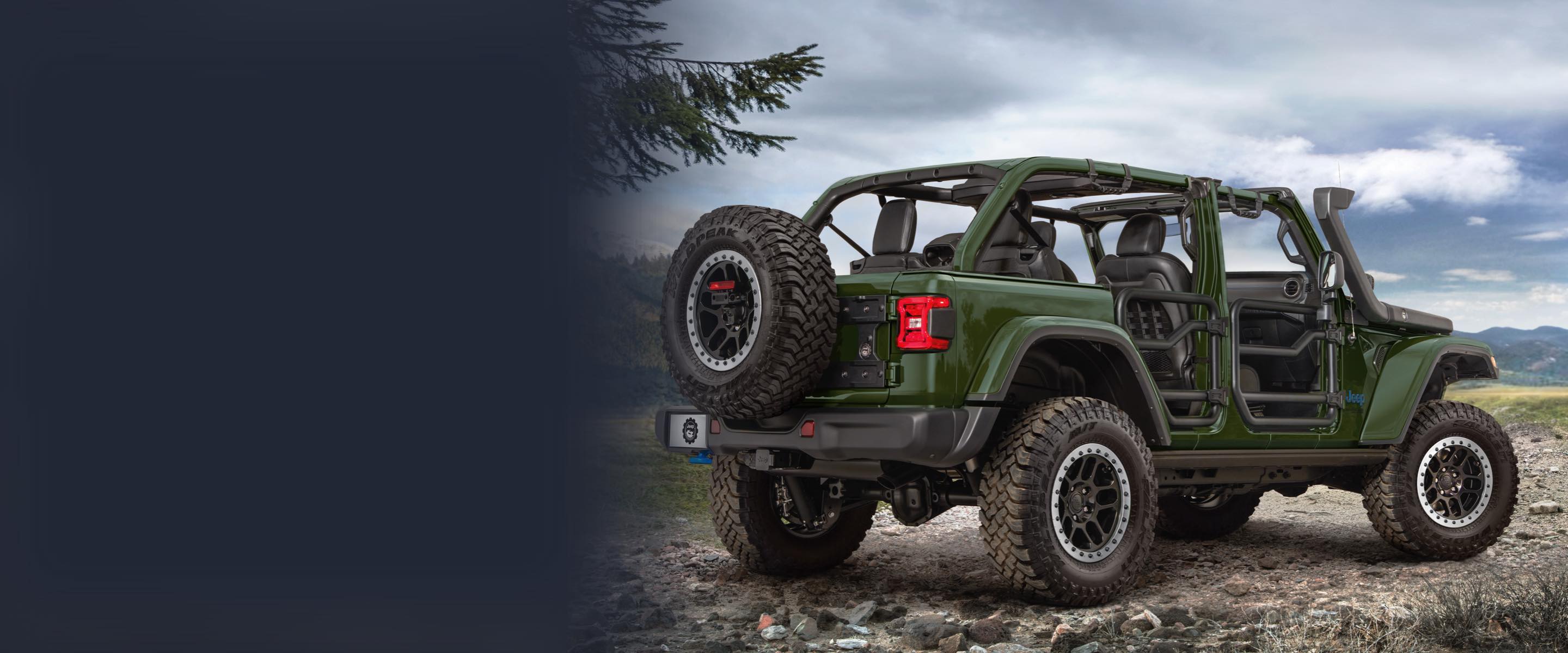 The 2022 Jeep Wrangler parked off-road. Its roof is off and it has been customized with an engine snorkel and tube doors.